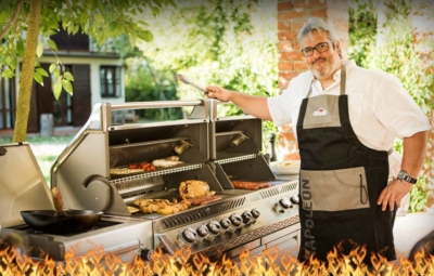 Ambientebild eines Napoleon Gasgrills mit verschiedenem Grillgut und dem Grillprofi