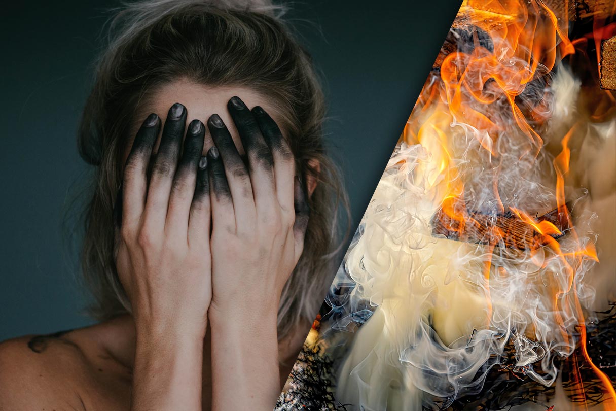 verzweifelte rußbefleckte Frau und qualmender Scheiterhaufen