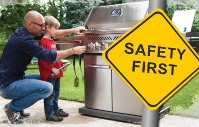 Bild Vater erklärt Sohn den Gasgrill und ein Safety First Schild
