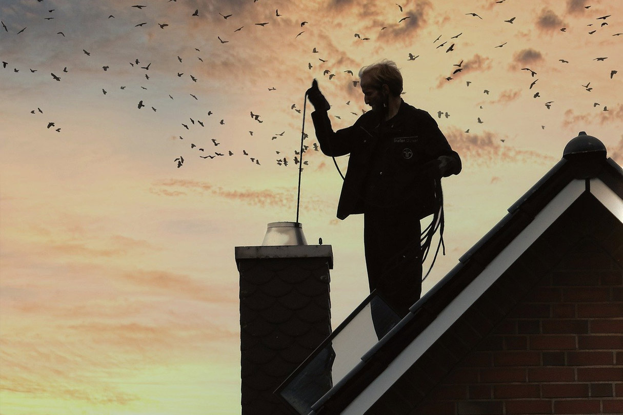 Schornsteinfeger auf dem Dach