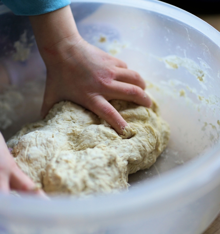 Knüppelbrotteig bestehend aus Wasser, Mehl und Sahne wird in einer großen Schüssel vermengt
